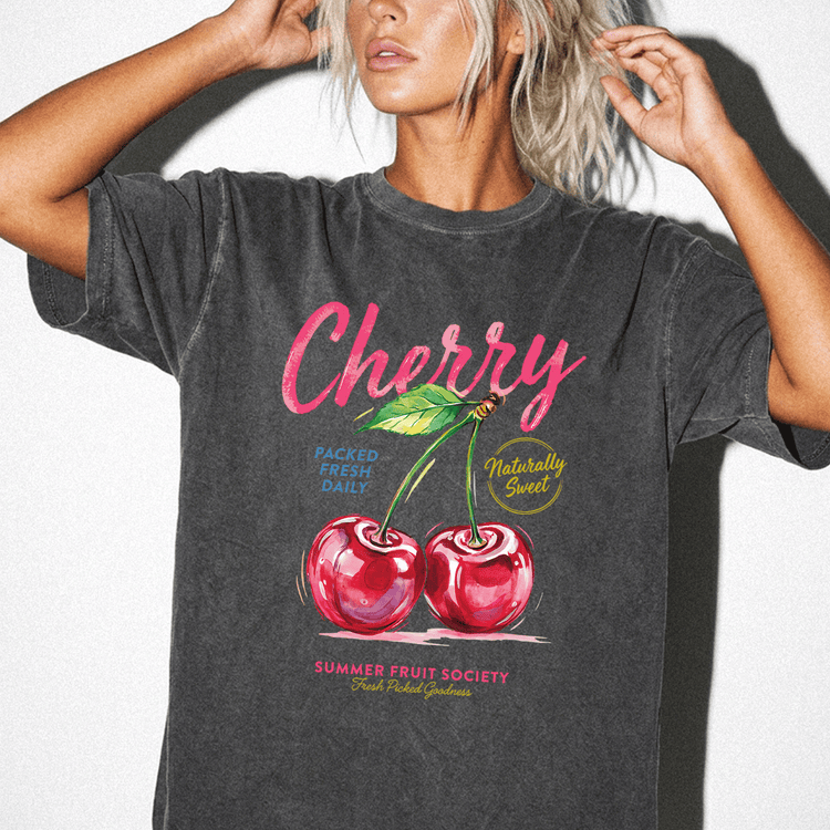 A woman wearing a black t-shirt with a graphic design of two cherries and text related to fruit.