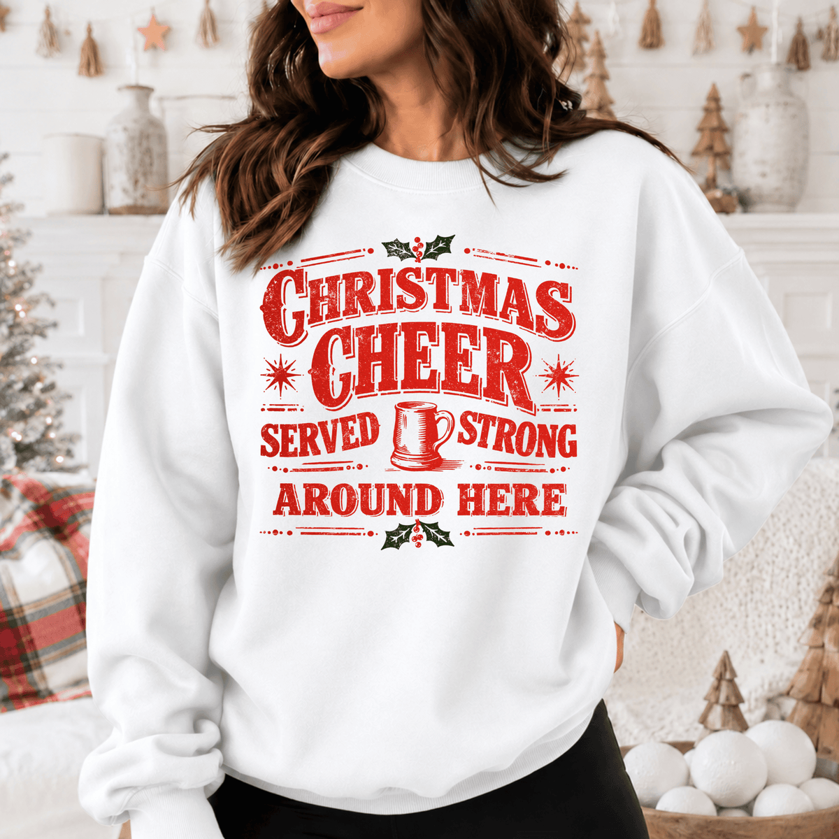 A woman wearing a white sweatshirt with a red and white Christmas cheer graphic and text printed on it.