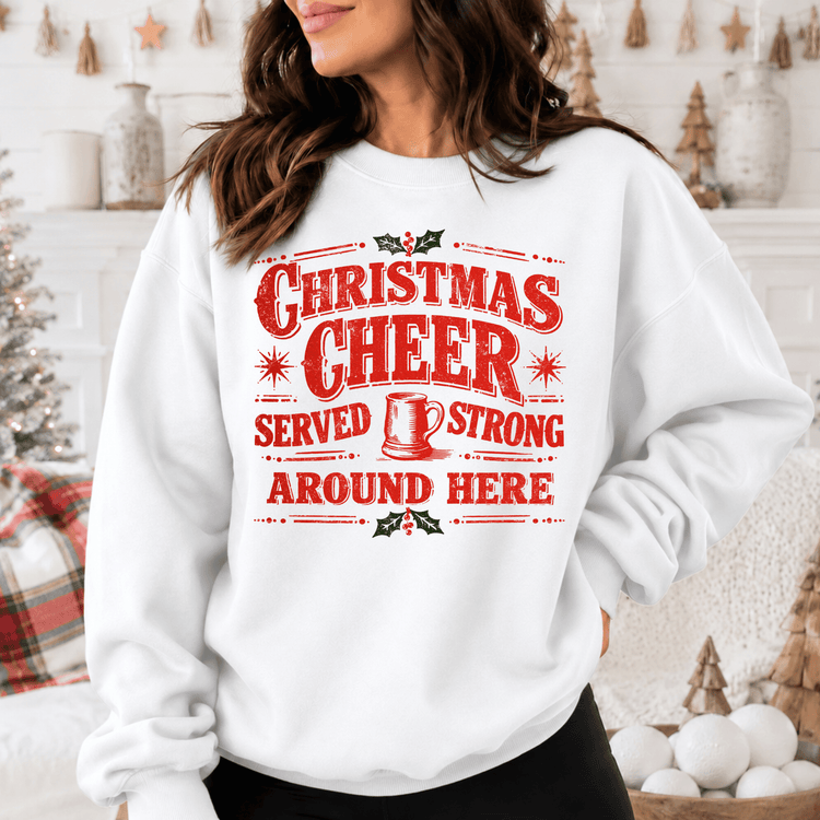 A woman wearing a white sweatshirt with a red and white Christmas cheer graphic and text printed on it.
