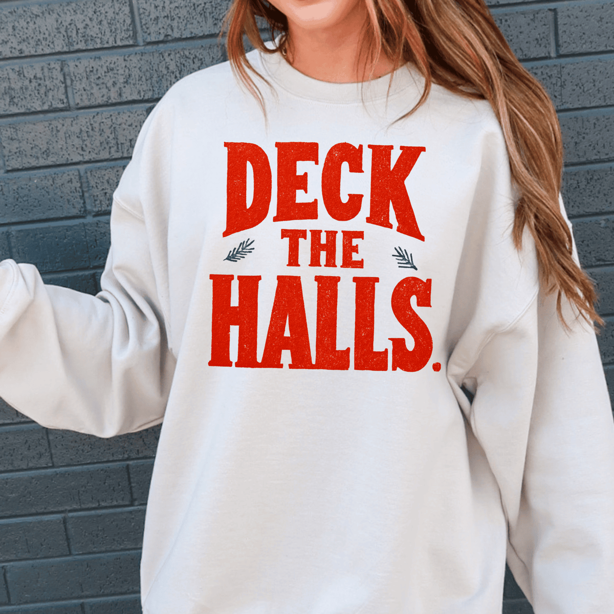A white sweatshirt with the text "DECK THE HALLS" printed on it in red and black letters.