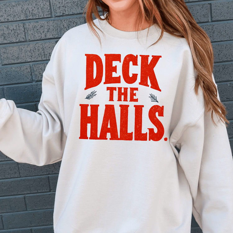 A white sweatshirt with the text "DECK THE HALLS" printed on it in red and black letters.
