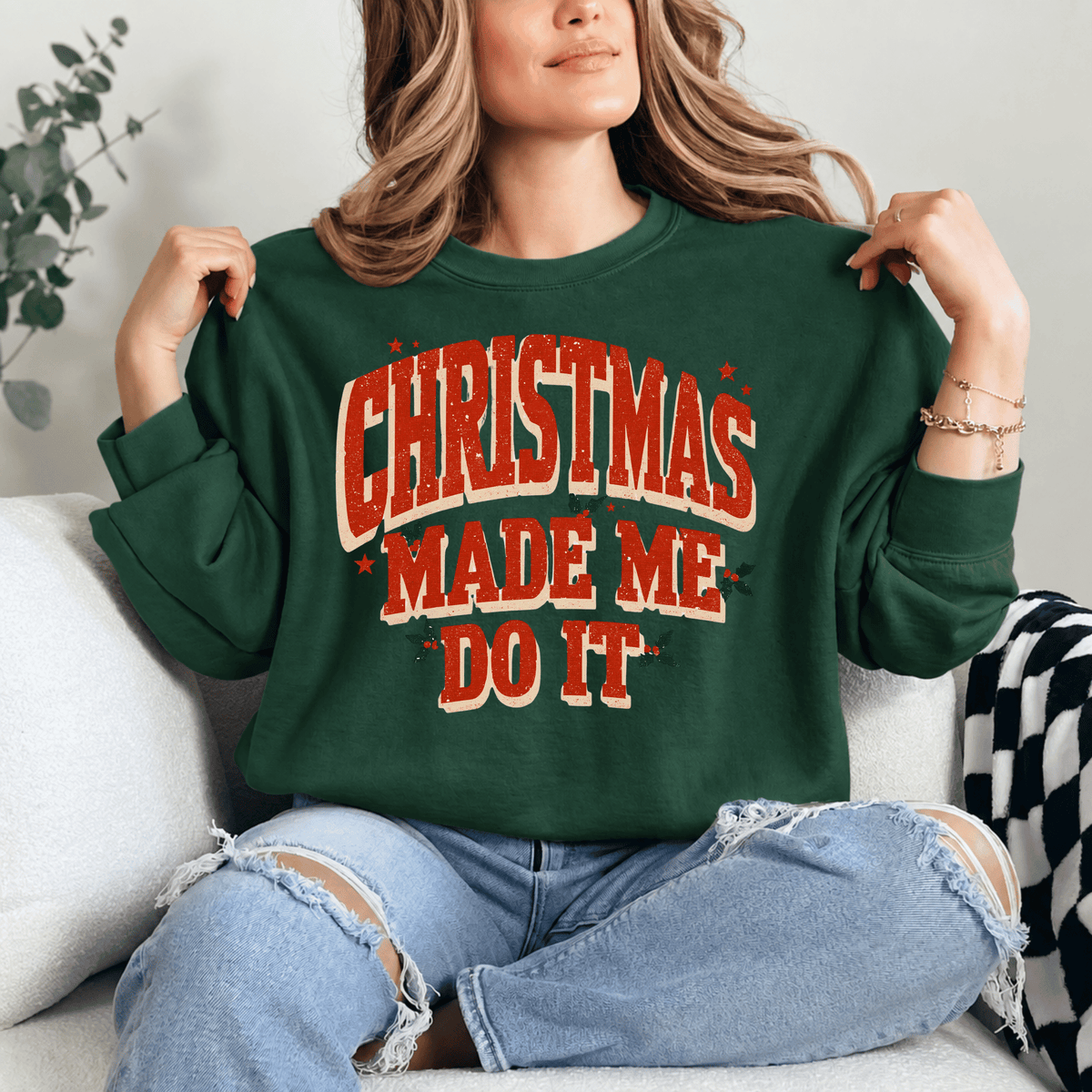 A woman wearing a green sweater with the text "Christmas Made Me Do It" is sitting on a couch.